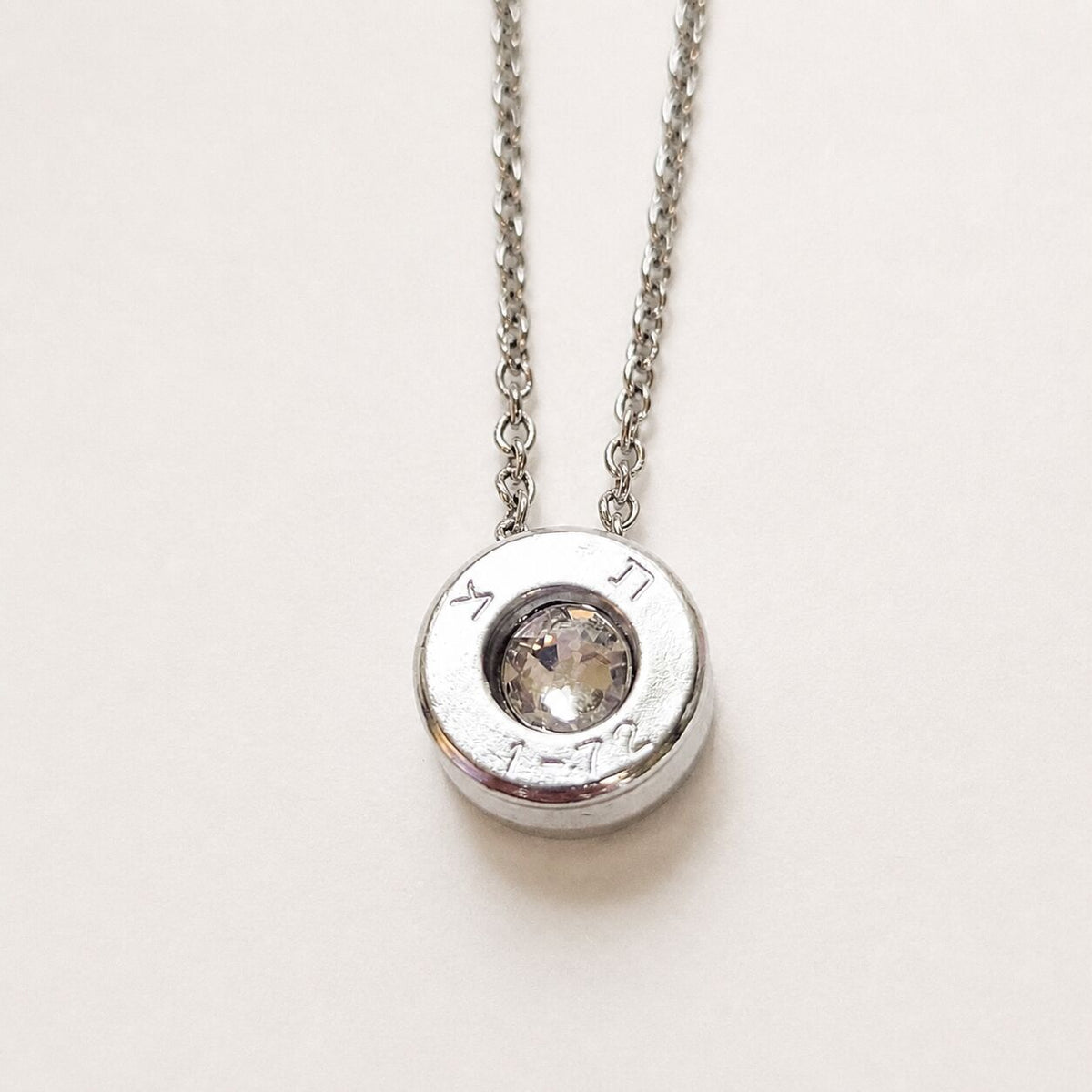 Bullet casing necklace in oxidized brass, rotated angle display by Alef Bet