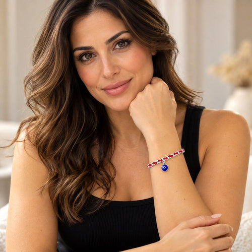 Evil eye red string bracelet featuring a sterling silver charm, promoting good luck and protection with a navy blue design.