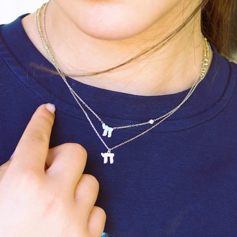 Chai Hebrew necklace featuring a sparkling pink or blue gemstone, crafted in sterling silver or 14k gold, perfect for Bat Mitzvahs.