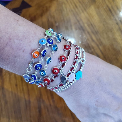 Colorful evil eye bracelets in gold or silver, featuring vibrant hues and protective symbols for luck and style enhancement.
