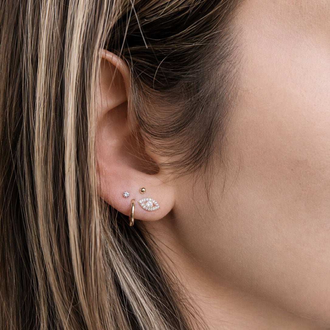 Evil eye hamsa diamond earrings in gold featuring bezel-set evil eye center by Alef Bet