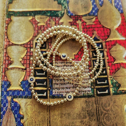 Red beaded evil eye bracelet with high-polish finish and eye motif by Alef Bet