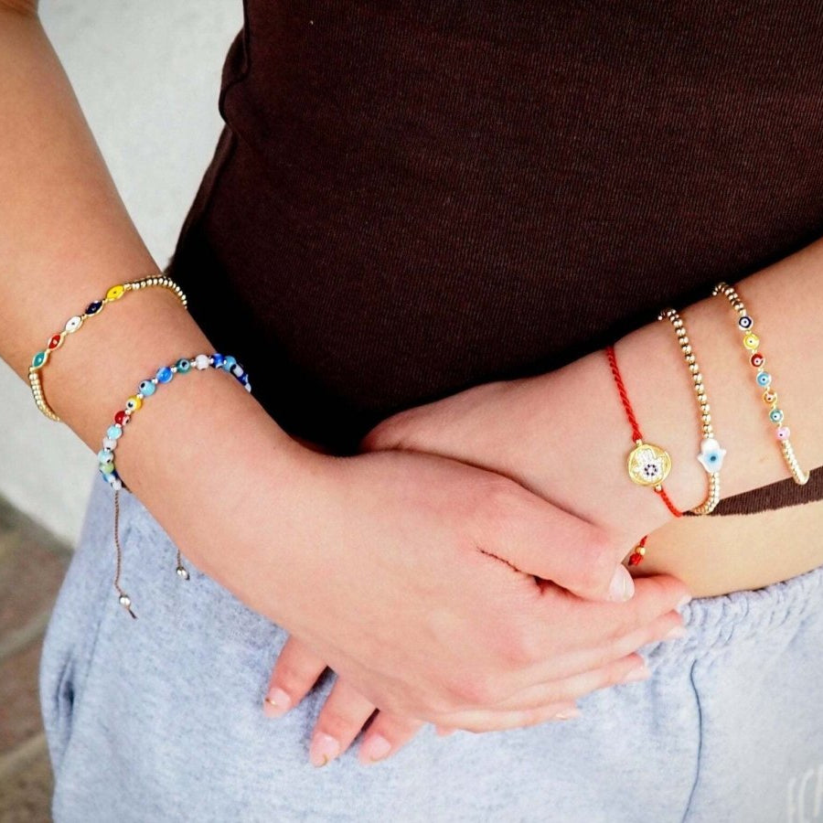 Close-up of hands with colorful bracelets on a neutral background