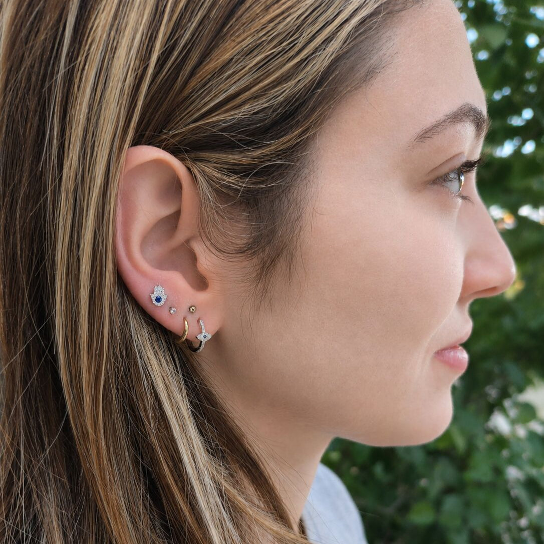 White gold evil eye earrings featuring bezel-set sapphire center with pave diamond halo by Alef Bet