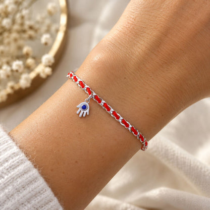 A handcrafted 925 sterling silver hamsa charm bracelet with a protective red string, gift wrapped and includes a description card.