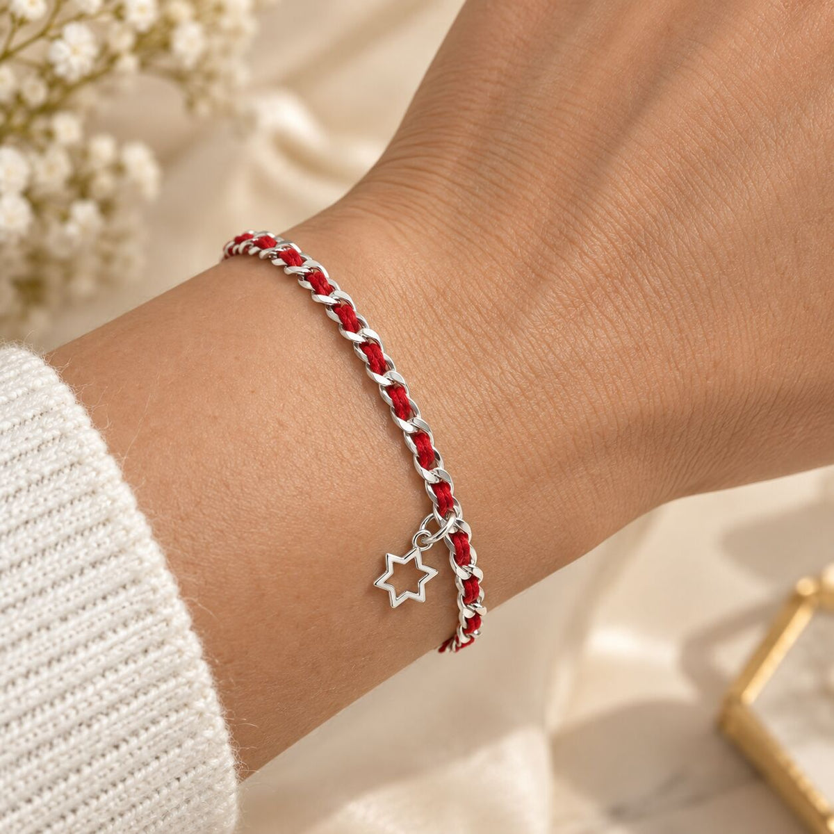Red string bracelet featuring a Star of David, symbolizing protection and faith, made with sterling silver and includes a description card.