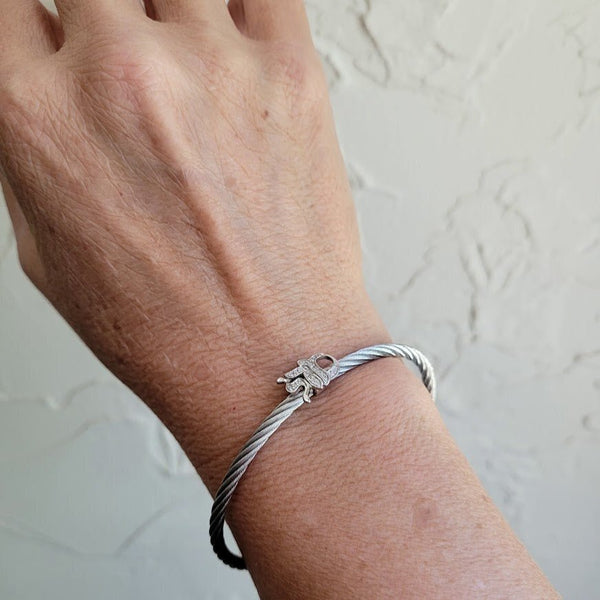 Modern jewelry stack featuring a Mazel bracelet, gold beads, and blue evil eye charm for good luck.