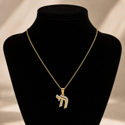 Elegant Chai symbol necklace in gold-tone, pave-set with diamond-like gems, symbolizing life, blessings, and happiness.