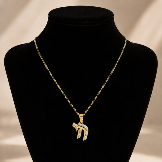 Elegant Chai symbol necklace in gold-tone, pave-set with diamond-like gems, symbolizing life, blessings, and happiness.
