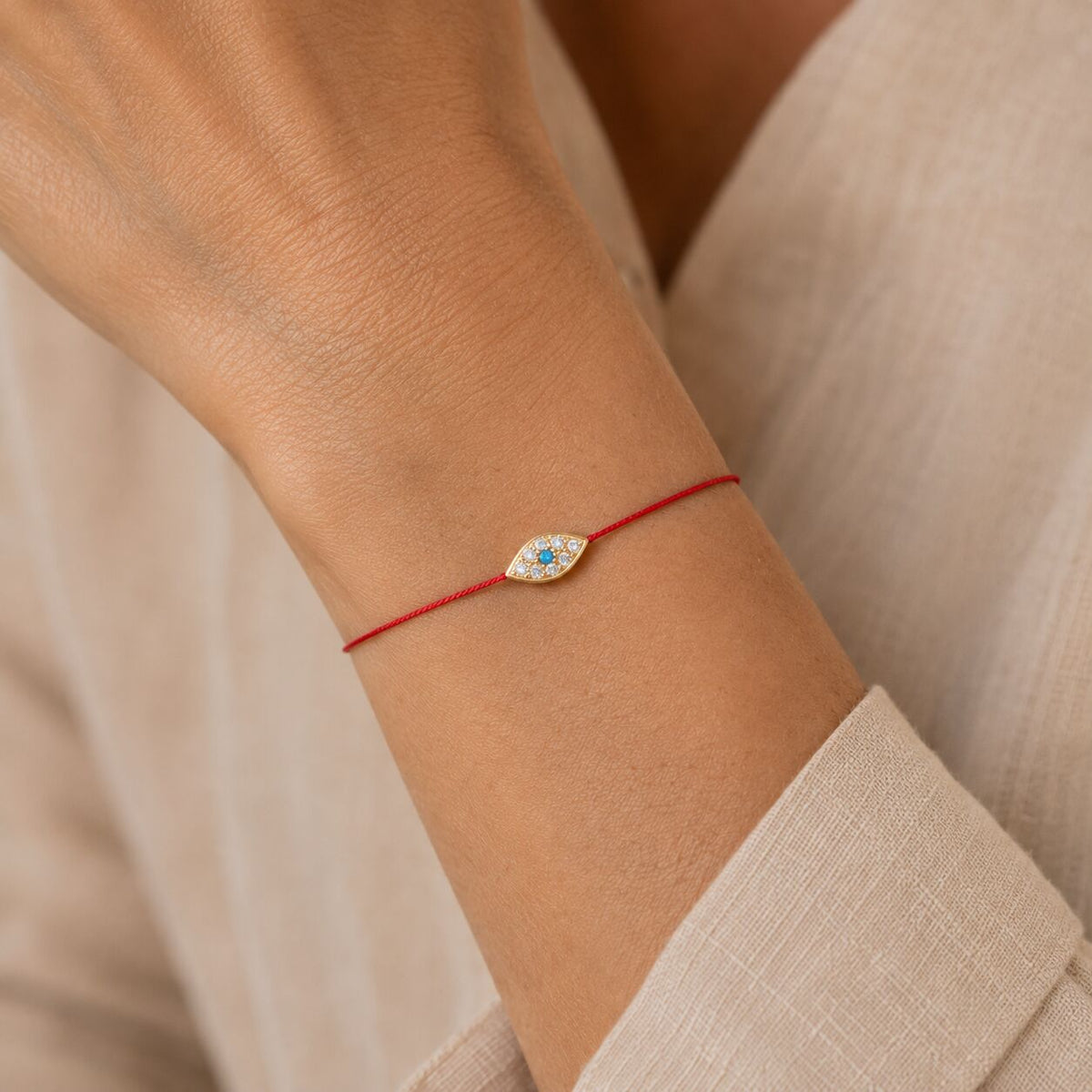Red cord evil eye bracelet featuring blue and white enamel eye accent by Alef Bet