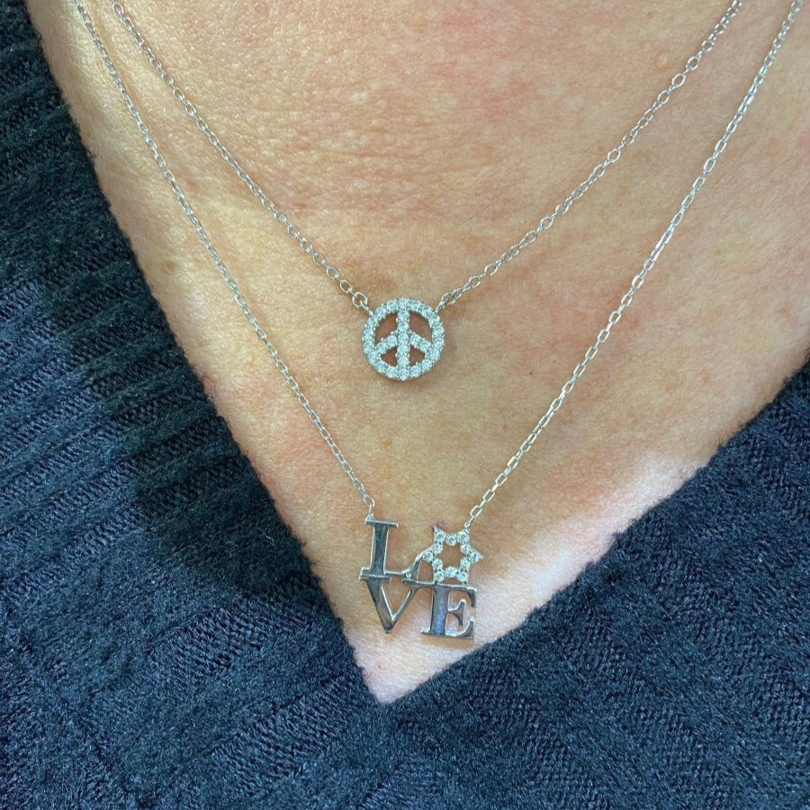 A sparkling sterling silver love letter necklace featuring L V E with a Star of David as the O, adjustable from 16" to 18".