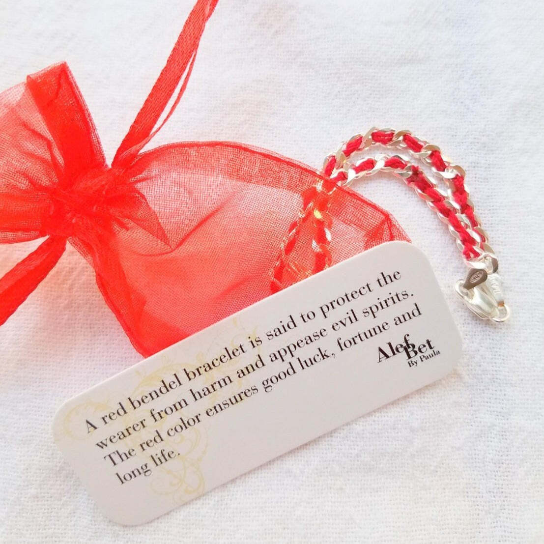 Solid silver heart charm bracelet with hand-woven red string, fitting a 7" wrist, perfect gift of love and protection.