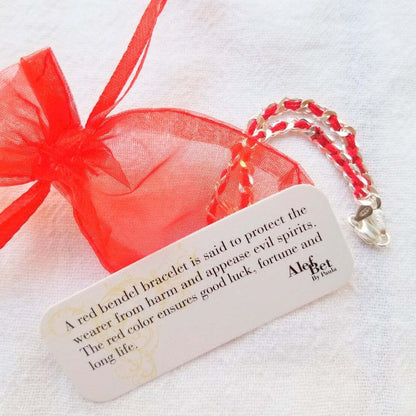 Solid silver heart charm bracelet with hand-woven red string, fitting a 7" wrist, perfect gift of love and protection.