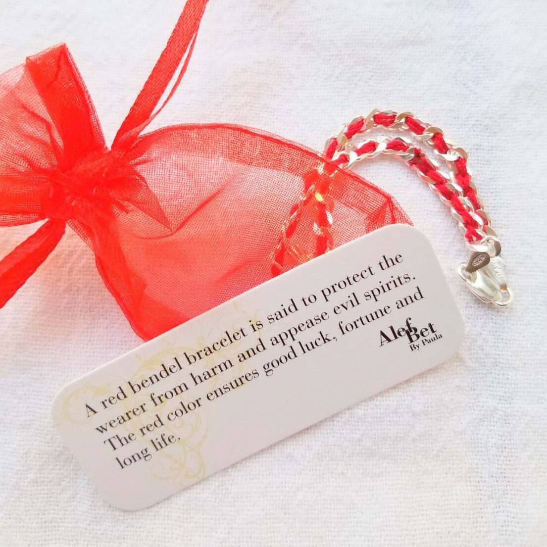 Sterling silver bracelet featuring a protective red string of fate and a Star of David charm, symbolizing Jewish faith.