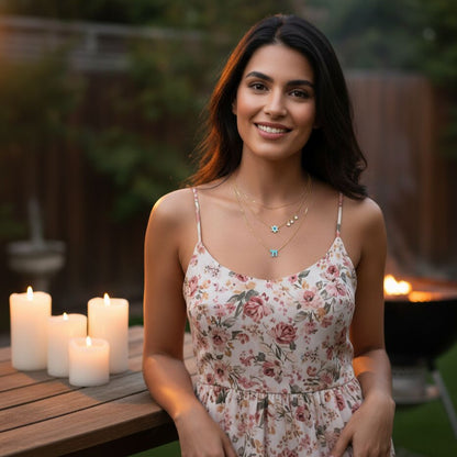 A layered necklace featuring two chains with a pink enamel Star of David and Chai symbol, accented by sparkling gems for a timeless look.