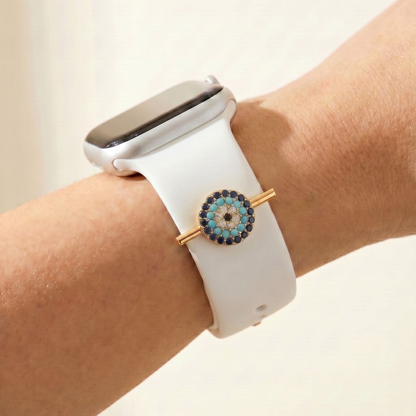 Smartwatch with a decorative evil eye charm wrist against a neutral background